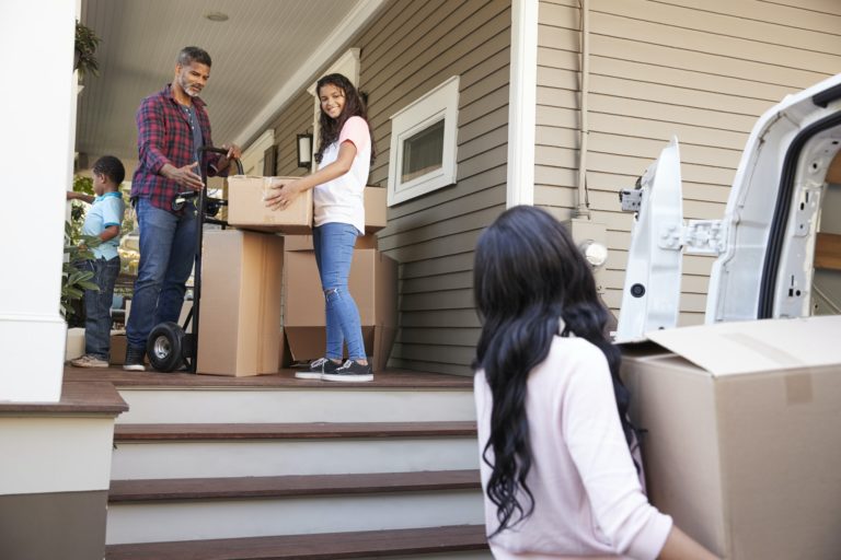 Children Helping Children With Boxes On Moving In Day