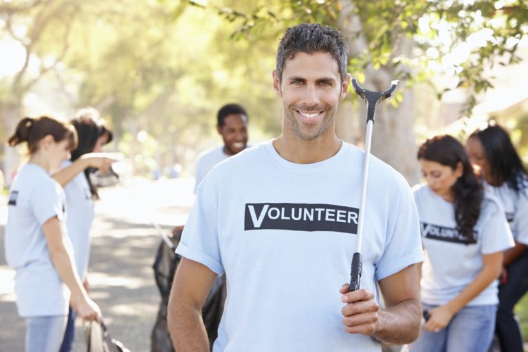 Team Of Volunteers Picking Up Litter In Suburban Street
