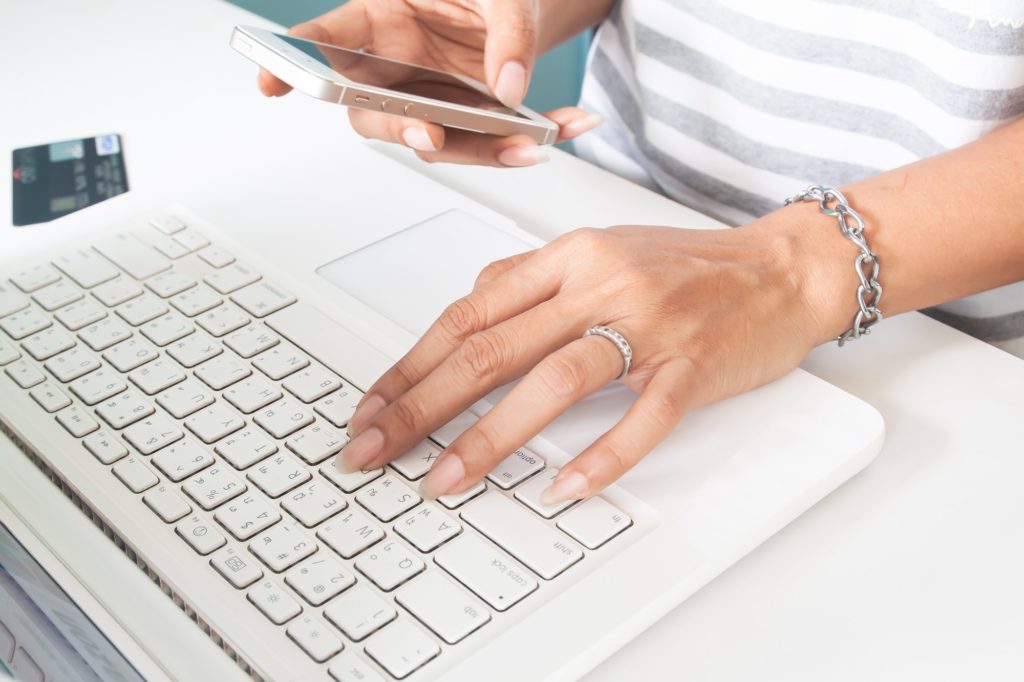 Close up woman using mobile phone and laptop. Business, Online banking, Online shopping