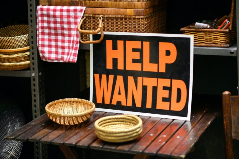 Help Wanted sign displayed in a shop in a job vacancy concept