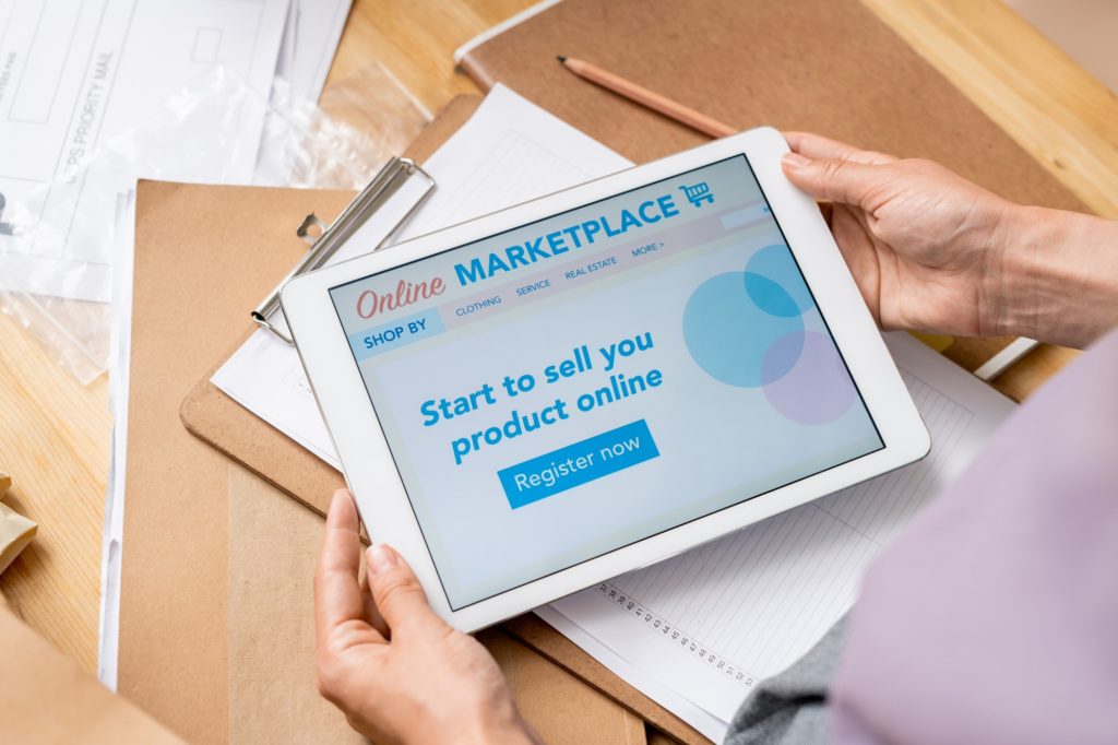 Hands of contemporary female manager of online shop with touchscreen