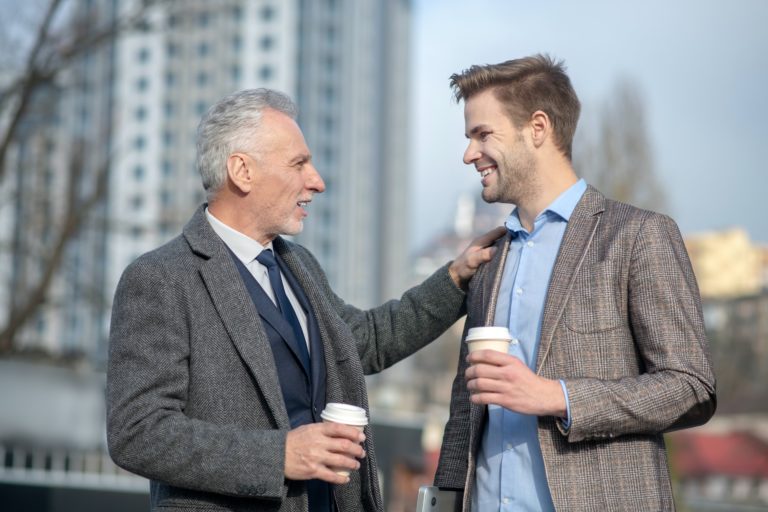 Young businessman and his mature mentor having a conversation